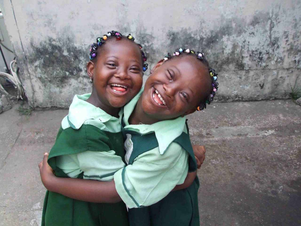 Two schoolgirls in uniform hugging